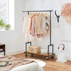 a bedroom with clothes hanging on the rail