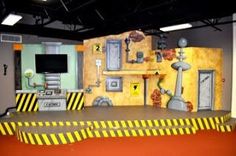 an indoor play area with yellow and black stripes on the floor, walls painted in different colors