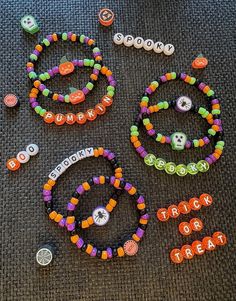 several bracelets with name beads and charms on the floor next to some magnets