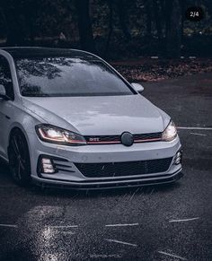 the front end of a white volkswagen golf gtr parked in a parking lot at night