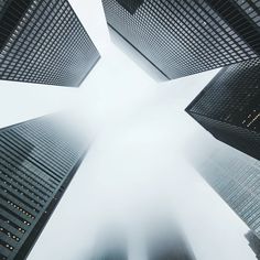 looking up at tall skyscrapers in the foggy cityscape on a cloudy day