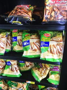 several packages of frozen meat are on display in a grocery store shelf with other packaged food items