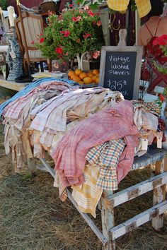 an outdoor market with clothes and flowers on display