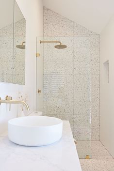 a bathroom with a sink, shower and large mirror in the corner on the wall