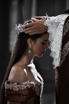 black and white photograph of a woman with long hair wearing a tiara, standing next to a man