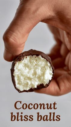 a hand holding a piece of coconut bliss balls with the word coconut bliss on it