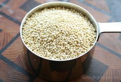 a pot filled with white sesame seeds on top of a wooden table