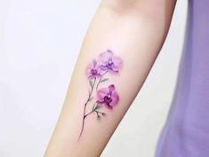 a woman's arm with purple flowers on the left side of her arm,