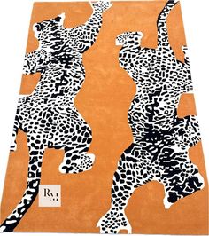 an orange rug with black and white animal print on the front, two giraffes standing in opposite directions