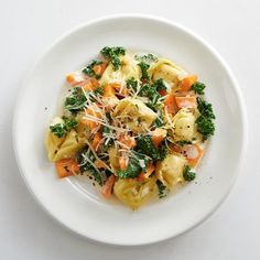 a white plate topped with pasta and veggies