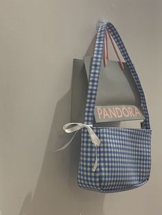 a blue and white bag hanging on the wall next to a sign that says pandara