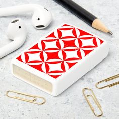 an apple airpods with red and white designs next to earbuds, paper clips, and other items