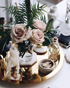 a tray with flowers and candles on it sitting on a table next to other items