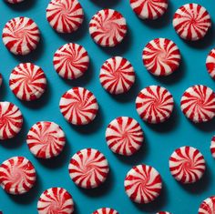 red and white candy canes are arranged on a blue surface