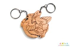 a wooden keychain with an image of two birds on the front and back