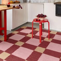 a red table sitting in the middle of a kitchen