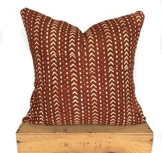 a brown and white pillow sitting on top of a wooden crate