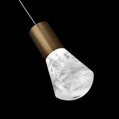 a white marble light hanging from a metal pole with a black background and gold trim