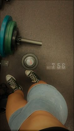 a person standing next to a pair of dumbbells with their feet on the ground