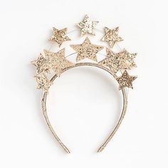 a gold headband with stars on it, against a white background for an article about how to wear glitter hair accessories