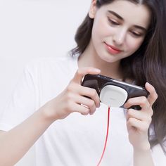 a woman is holding a cell phone and listening to music