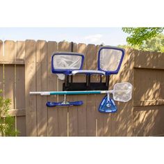 two blue and white plastic objects hanging on a fence next to a wooden privacy wall