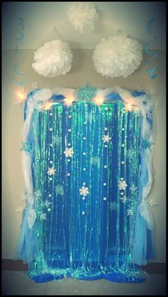 a blue curtain decorated with snowflakes and lights