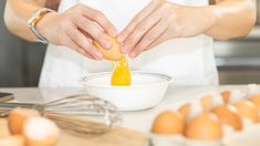 a person is pouring orange juice into a bowl with eggs on the counter in front of them