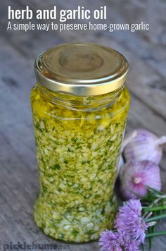 a jar filled with herbs and garlic oil