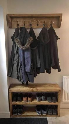 a coat rack with shoes and coats hanging on it