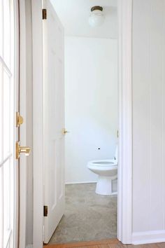 an open door leading to a bathroom with a toilet