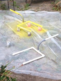 an outdoor area with plastic covering the ground and various items on it, including a yellow object