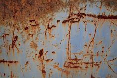 an old rusted metal surface with some writing on it