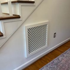 an air conditioner on the side of a stair case next to a carpeted floor