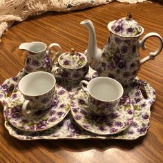 a tea set with purple flowers on it