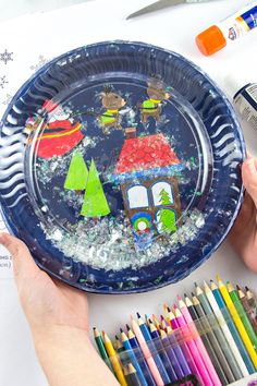 a paper plate with christmas decorations and crayons on it