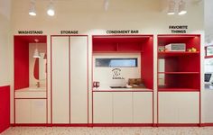 the interior of a store with red and white shelves on each side, including a cash register