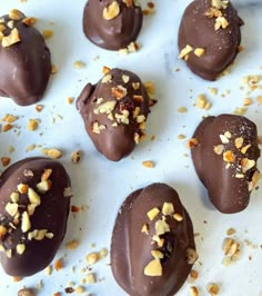 chocolate covered candies with nuts scattered around them