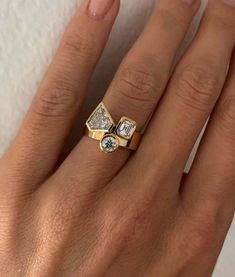 a woman's hand wearing a yellow gold ring with two diamonds on the band