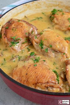 some chicken is cooking in a pot with gravy and parsley on top