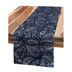 an image of a table runner on top of a wooden board with blue and white paisley print