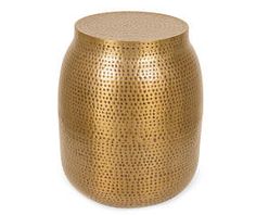 a gold metal stool with holes on the top and bottom, against a white background