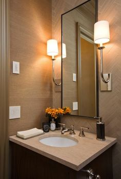 a bathroom sink sitting under a mirror next to a wall mounted faucet with lights on it