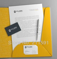 a yellow folder with a business card and pen on it, next to an envelope