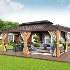 a patio covered in furniture and curtains on top of a wooden deck next to a house