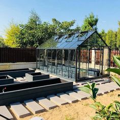 a small greenhouse in the middle of a yard with steps leading up to it and an open roof