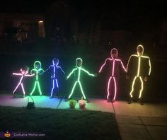 several lighted figures are standing in the dark