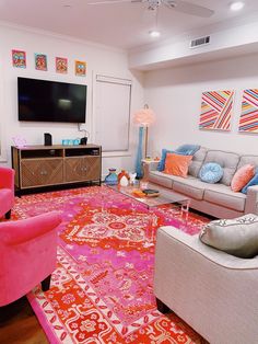 a living room filled with furniture and a flat screen tv mounted to the side of a wall