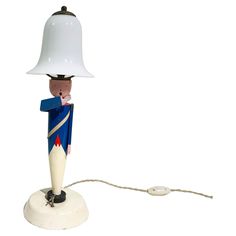 a lamp that is on top of a white base with a blue and red design