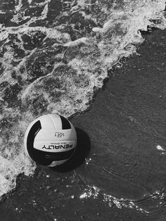 an inflatable beach ball floating on the water at the edge of the ocean